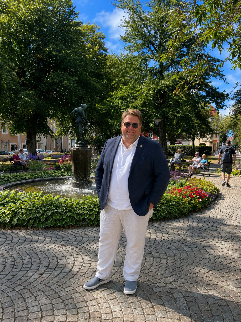 Pierre Gustafsson i kavaj framför fontänen på Stortorget i Ängelholm